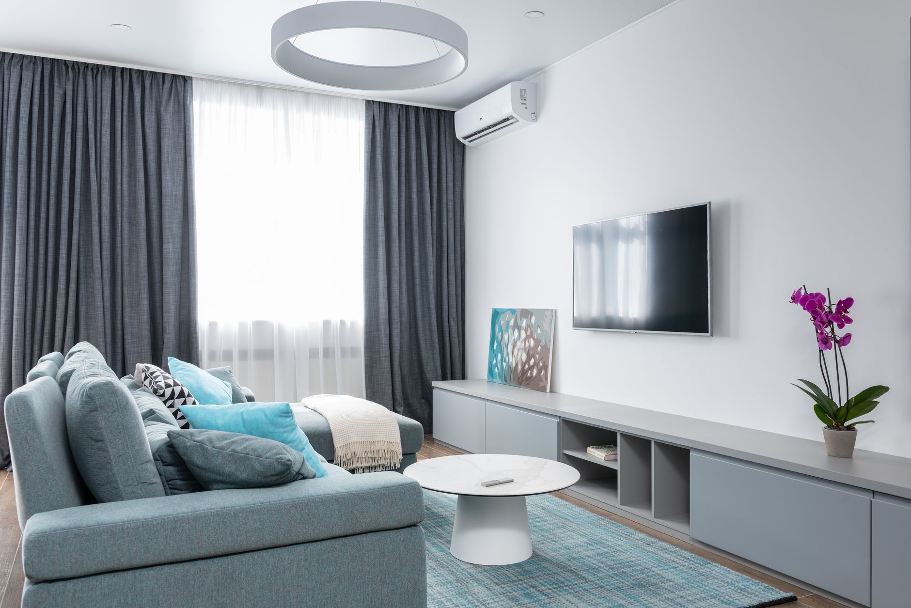 White wall mounted mini split indoor unit heating a bright living room