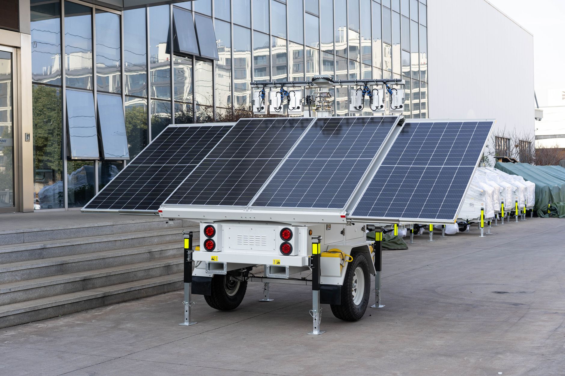 Portable battery power station connected to solar panels beside a house wall